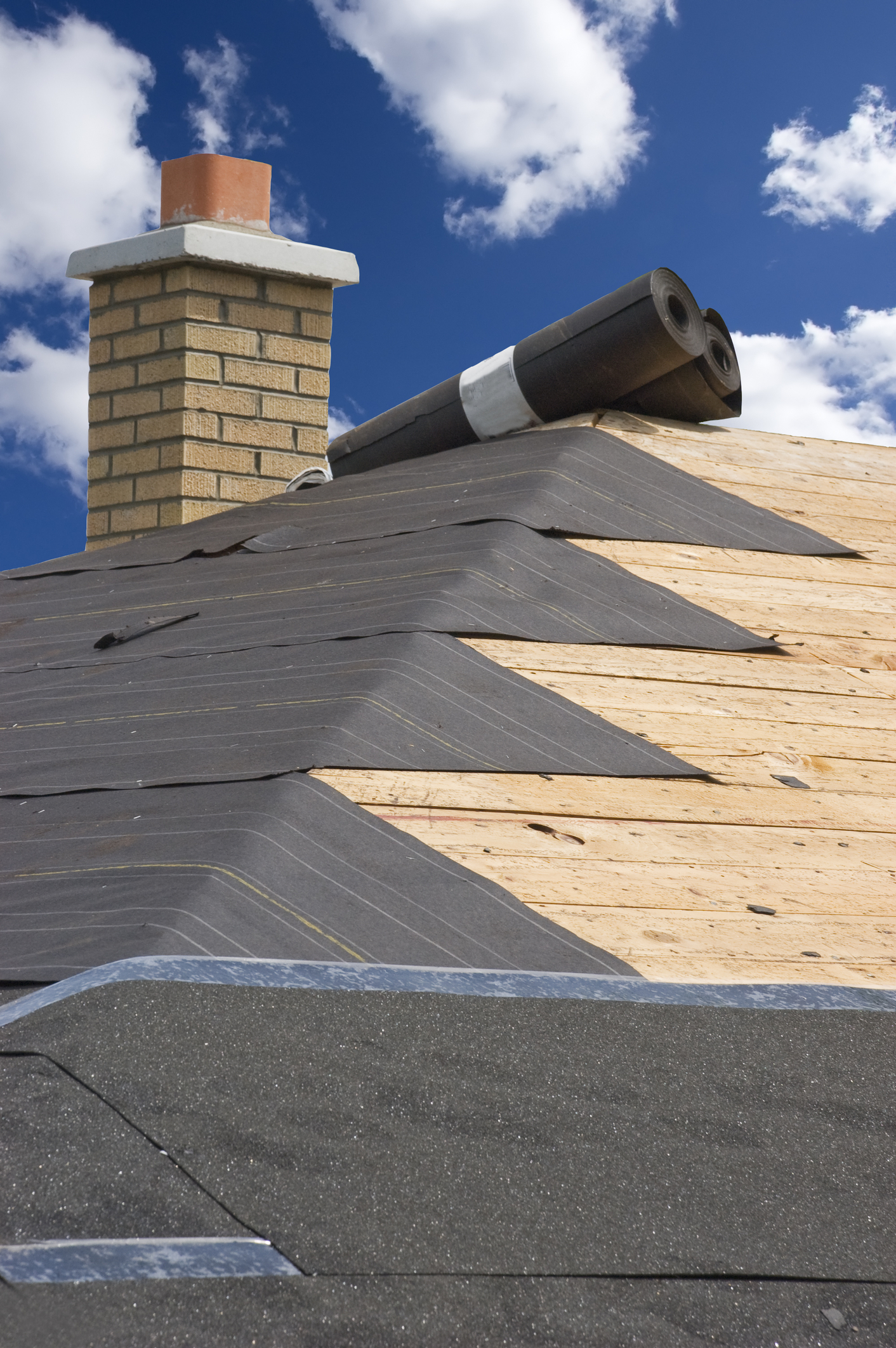 Concept for roof, home repairs, maintenance on the house, and construction. Shingles and a leaking roof are a big headache for homeowners. It can be tough finding a good contractor. Tar paper and an ice barrier can be seen in this image.